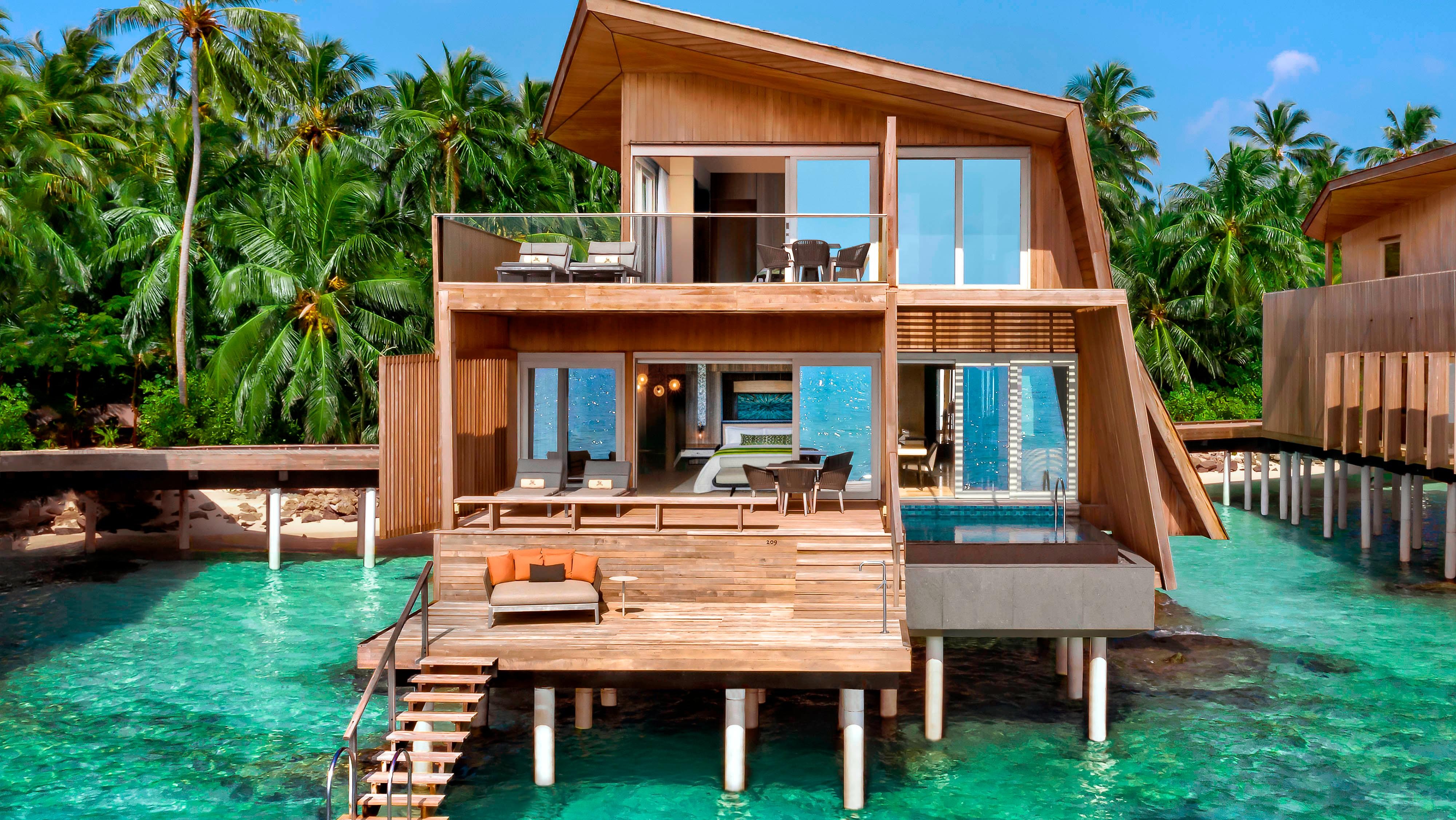 The Two-Bedroom Sunset Overwater Villa seen from the lagoon at dusk